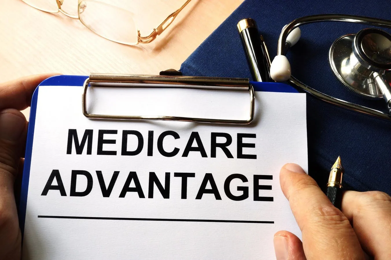 A senior reviewing Medicare Advantage plan papers and comparing coverage options