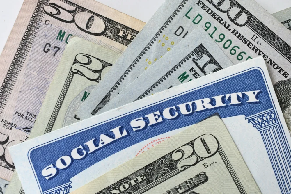 Social Security card and benefit statement beside a calendar and calculator