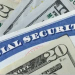 A Social Security card and calculator beside retirement paperwork