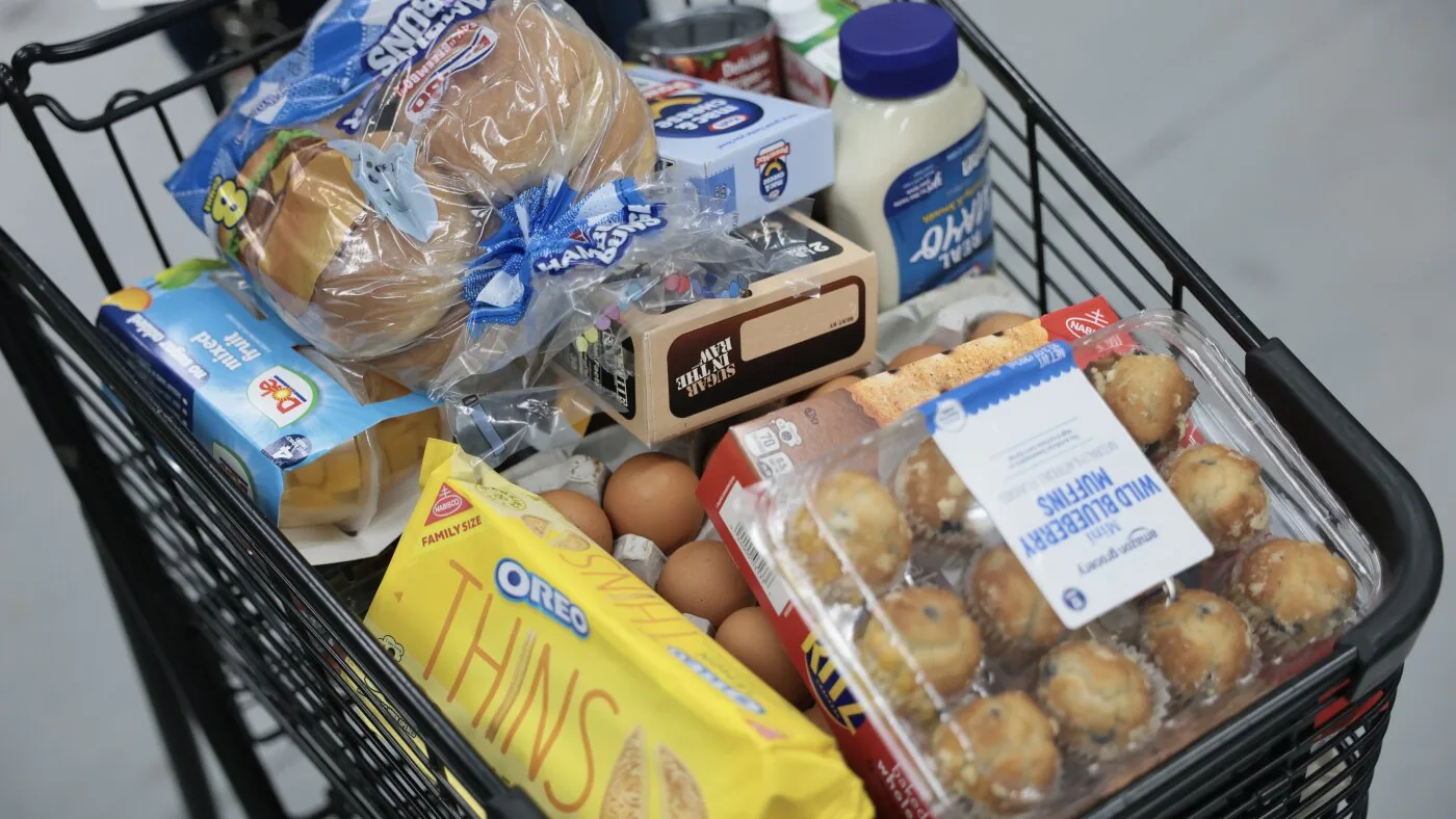 Shopping cart in a grocery store aisle tied to SNAP food assistance